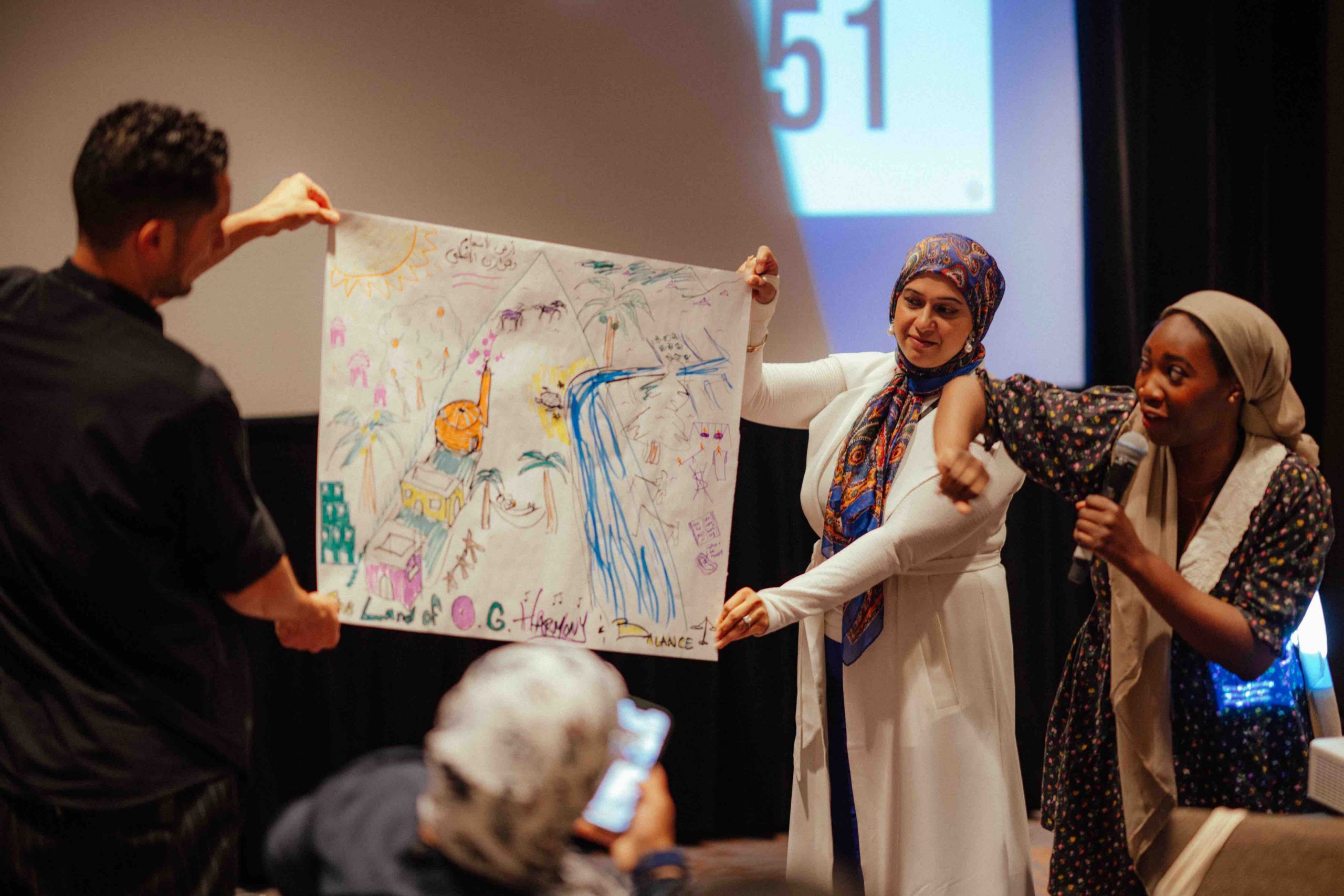 A group of convening attendees holds up a large white piece of paper filled with hand illustrated drawings