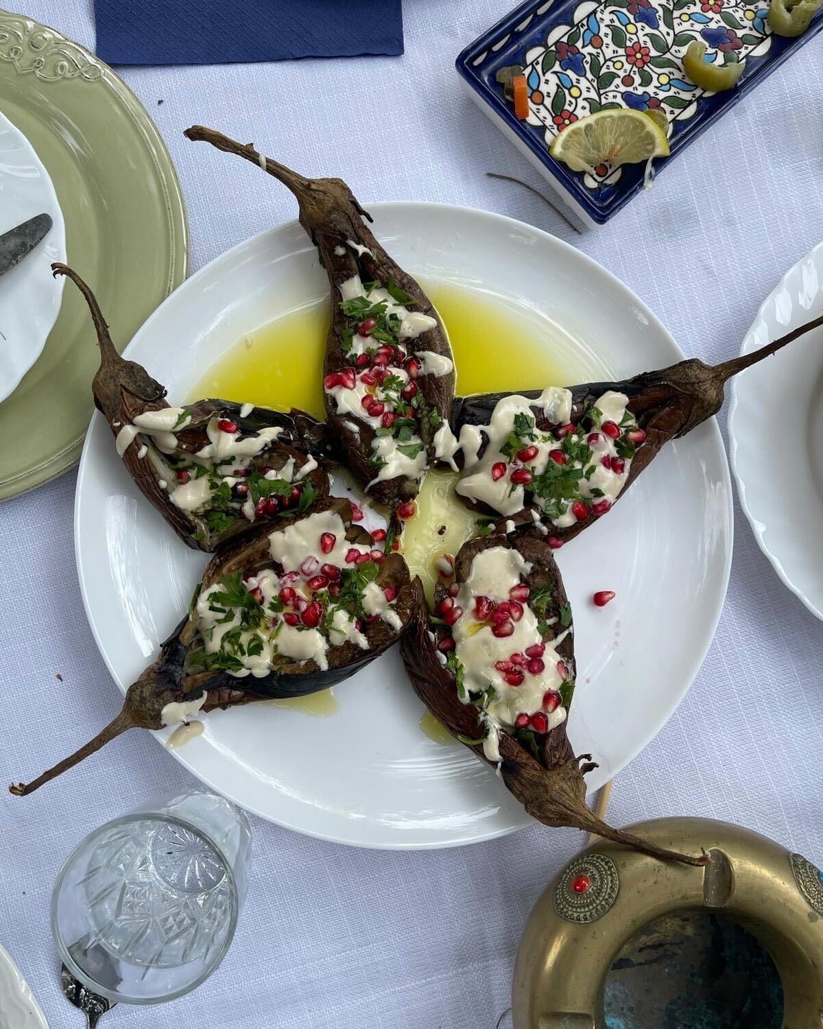 A photo of a plate with a Palestinian dish featuring eggplant and pomegranate